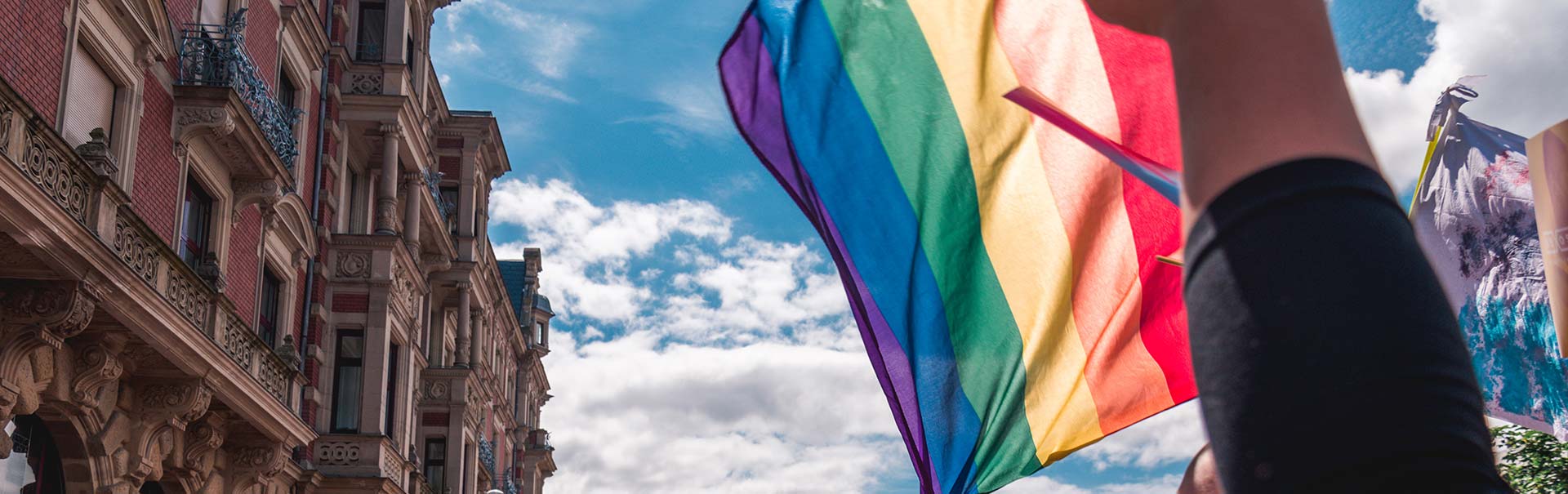 a rainbow flag flies next to a paris building